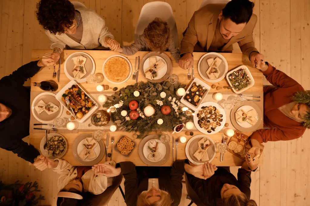 A family of four gathered around a table, smiling and eating dinner together.